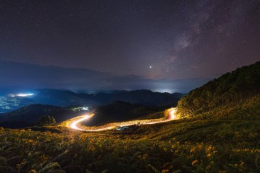 Samanyolu 'nun muhteşem manzarası Ağaç Marigold tarlasının üzerinde yıldızlı ve Doi Mae U Kho' nun kırsal kesimindeki dağ tepesinde hafif patika, Mae Hong Son, Tayland
