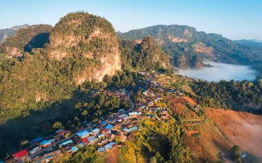 Beautiful aerial view of colorful roof of traditional village nestled among foggy mountain in countryside at Ban Jabo, Pang Mapha, Mae Hong Son, Thailand clipart