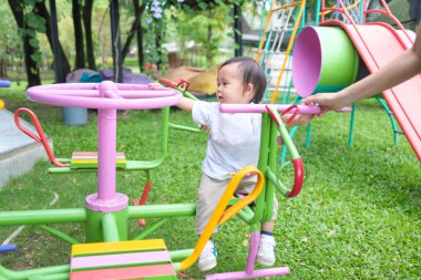 Neşeli Asyalı çocuk şen şakrak eğleniyor oyun parkındaki çimlerin üzerinde