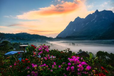 Doi Luang Chiang Dao kireçtaşı dağı üzerinde nefes kesici bir gün doğumu sis denizi ve yerel kabile köyü üzerinde Ban Na Lao Mai, Chiang Dao, Chiang Mai, Tayland