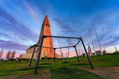 İzlanda 'da yaz aylarında Reykjavik şehir merkezinde gün batımında canlı bir gökyüzü olan güzel kutsal Hallgrimskirkja Lutheran Kilisesi.