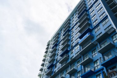 Çağdaş mimari tasarımı ve balkonu ve cam pencereleri olan mavi cephe modern apartman dairesi