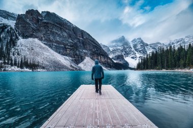 Banff Ulusal Parkı, Alberta, Kanada 'da Moraine Gölü' ndeki Rocky Dağları 'nda yalnız bir yolcu iskelesinde yürüyor.