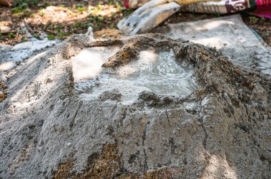 İnşaat işçisi geleneksel bir beton hazırlık yöntemi olan kürek ve mala kullanarak kum, çimento ve suyu elle karıştırıyor.