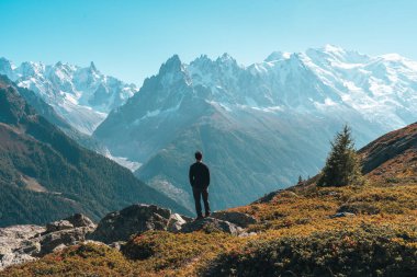 Fransa 'nın Chamonix kentindeki Lac Blanc, Fransa' da sonbaharda patika boyunca erkek yürüyüşçülerin ayakta durması ve Mont Blanc dağ manzarasının keyfini çıkarması başarıya ulaştı.