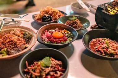 Asya Isaan füzyon tarzı yemek mutfağı çeşitli nadir bulunan sebzeli domuz eti, baharatlı salata ve Tayland restoranındaki masada soba.