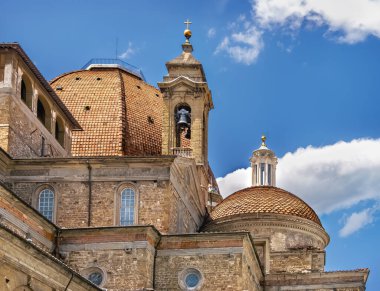 Ortaçağ kilisesi kiremitli çatısı ve açık gökyüzünde taştan yapılmış kubbesi ve bulutlu arka planı var.