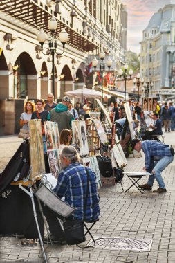 Şehir merkezindeki binaların arka planında sanatçılar olan turistik bölge