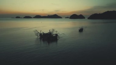 Vietnam 'ın balık tutma geleneğini göz kamaştırıcı hava manzaralarıyla keşfedin. Gün batımına karşı siluetlenmiş, geleneksel tekneler balıkçıların otantik yaşam tarzını ortaya koyuyor.