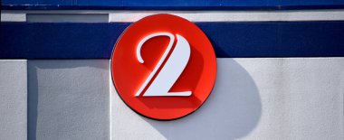 Building, with blue stripe, has circle displaying the number two.  Circle is red. clipart