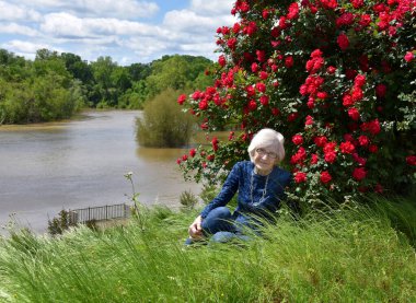 99 yaşında güzel bir kadın, hala yüksek yaşam kalitesine sahip. Uzun bahar çimlerinde oturuyor ve açık havayı, çiçekleri ve Ouachita Nehri manzarasını süslüyor..