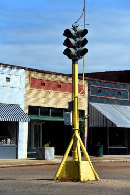 Eski moda trafik lambaları şehir merkezindeki küçük bir meydanın ortasında sarı bir boru hattında durur..  