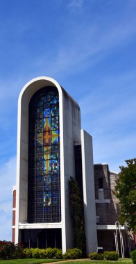 Central Baptist Church in Springhill, Louisiana, has a huge arching front window, featuring a stained glass window of a cross. clipart