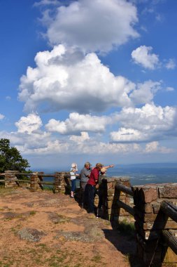 Aile, Arkansas Dağı 'nın tepesinden eyaletleri hakkında aynı görüşü paylaşıyor. Magazine State Park 'ta. Aileden biri ilgi alanına işaret ediyor. Bulutlar dokunulabilirmiş gibi hisseder..