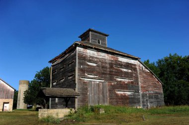 Eşsiz ahır yapısının tepesinde kubbe var. Bir zamanlar ahır beyaza boyanmıştı ve tepesindeki yıpranmış kalıntıları görebilirsiniz. Taş su kuyusu önde oturur..