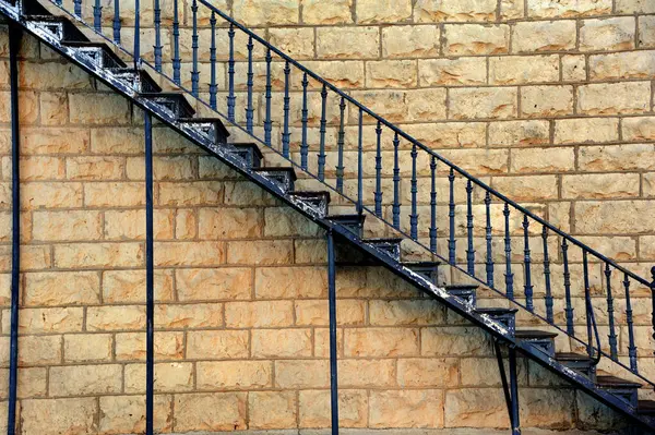 stock image Wrought iron vintage stairs ascend the side of an historic building in Central Kansas.  Paint on steps is peeling and cracked.