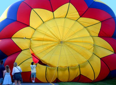 Sıcak Hava Balonu, Kingsport, Tennessee 'deki Hot Air Balon Festivali sırasında uçuşuna hazırlanırken genişler ve şişer. Seyirciler, işçiler hazırlarken izliyorlar..