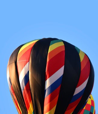 Colorful hot air balloons float in a blue sky and are ready to lauch at the Kingsport Tennessee Hot Air Balloon Festival. clipart