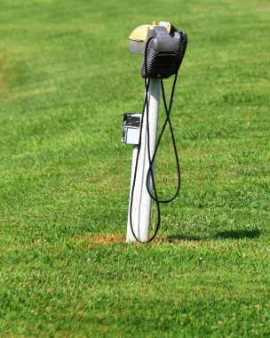 Pair of vintage speakers hang from pole in the parking area for a drive in movie theater. clipart