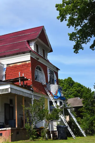 stock image Two ladders lean against an old Victorian home.  It is undergoing a massive renovation and replacing old windows with new.