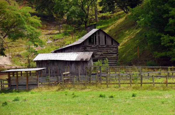 stock image Old, wooden pole barn sits in front of a pole silo.  Small corral is fenced with posts and wooden boards.  Barn sits in small valley in the Appalachian Mountains.