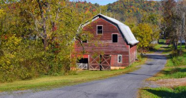 Eski kırmızı, ahşap ahır Tennessee 'deki kır yolunun yanında duruyor. Appalachian Dağları Arkasında Yüksel.