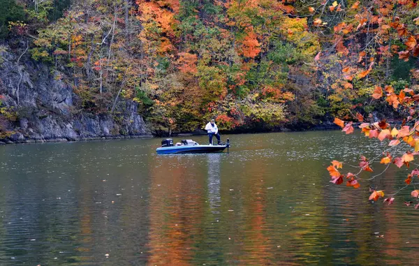 stock image Fisherman wets a line on the calm waters of the Holston River in Warriors Path State Park in Kingsport, Tennessee.  Autumn has colored the trees.