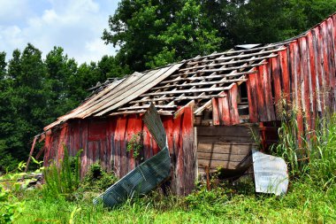 Harabenin son aşamaları, eski kırmızı ahşap ahırın çatısından kalay söken şiddetli rüzgarlarla tamamlandı..