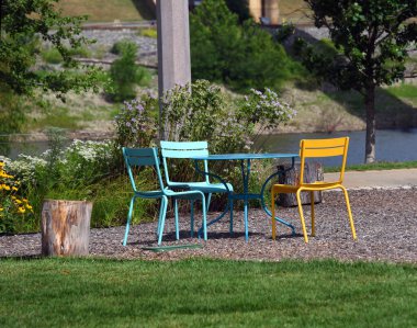 River Garden, in Memphis, Tennessee, has colorful metal table and chairs for picnicing, relaxing or just a peaceful oasis in a busy city. clipart