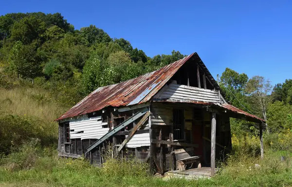 stock image Old Appalachian country store stands closed and in ruins.  Wooden bench sits on front porch.  Tin roof is rusty and patched.