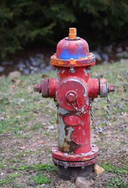 Su musluğunun üzerinde 2006 rakamları var. Yangın musluğu çok renkli ve paslanmış. Boya çatlamış ve soyulmuş..