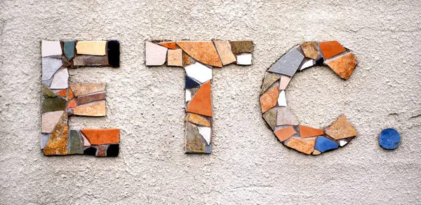 stock image The word et cetera is formed from grouping broken tile into the letters ETC.  The background is textured concrete.