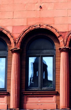 Houghton, Michigan 'daki tarihi Douglas Oteli yıkık dökük bir binanın camına yansıyor. Camdaki kemerler kırılmış ve bozuluyor. Bina Redsandstone bloklarından inşa edilmiştir..