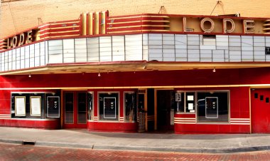 Another movie theater closes down.  The Roger's Cinema Lode Luxury 3 in downtown Houghton, Michigan is closed.  Marquee is empty.  Building is red with yellow brick. clipart