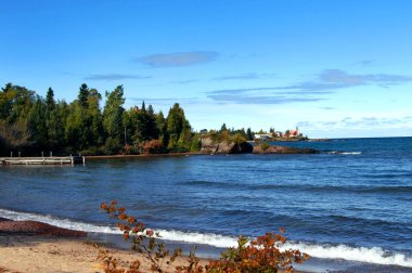 Ahşap iskele, Superior Gölü, Michigan 'da kırsal ve yıpranmış olarak görüntülenir. Arka planda Kartal Limanı Deniz feneri ve Keweenaw Yarımadası görünüyor.