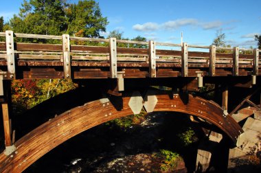 Eagle River Falls Köprüsü, Yukarı Yarımada, Michigan 'da tarihi bir simgedir. Ahşap kirişler nehir boyunca kemerler.