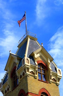 120 yaşında, Houghton, Michigan 'daki Viktorya dönemi mahkeme binası çatısı için yerel kırmızı kumtaşı ve Superior Gölü bakırı ile tasarlandı. Mansard çatısında bayrak dalgalanıyor..