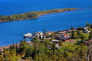 Brockway Mountain yolu Isle Royal tekne iskelesine ve çevresindeki binalara bakıyor. Copper Harbor ve Superior Gölü 'nün canlı mavi suları görüntüyü doldurdu.