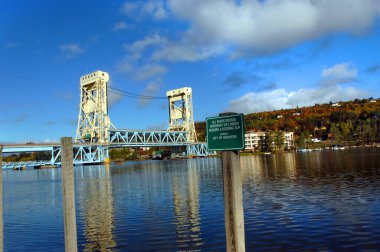 Portage Gölü, Hancock ve Houghton, Michigan 'ı birbirine bağlayan Portage Lake Asansör Köprüsü' nün görüntüsünü yansıtır. Quincy Hill arka planda sonbahar rengiyle kaplıdır.