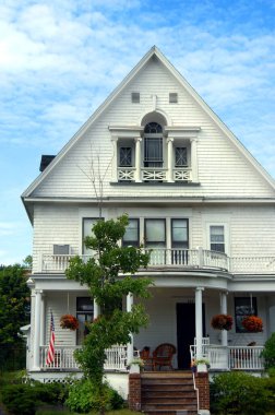 Viktorya döneminden kalma bir ev gibi görünüyor. Ön verandası, balkonu ve Amerikan bayrağı var. Ev Hancock, Michigan 'da..