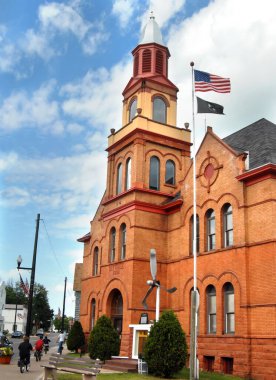 ABD 'nin küçük bir kasabası bu resimde, kaldırımda bisiklet süren çocuklar, 4 Temmuz' da bayraklar dalgalanıyor ve trafik yok. Görüntü, Linden Gölü, Michigan 'daki Linden Village Hall ve İtfaiye İstasyonu' na ait..