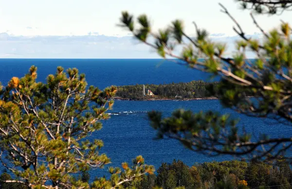 stock image Surrounded by Lake Superior and Copper Harbor, the Copper Harbor Lighthouse is framed by trees on the Brockway Mountain scenic drive.