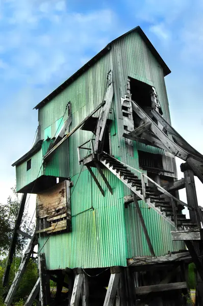 stock image Long abandoned, shaft house, is a landmark of the copper mining industry in Upper Peninsula, Michigan.  Shaft house is green metal with wooden supports and staircase.