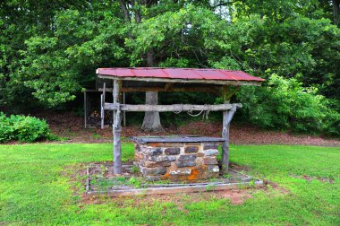 Eski moda su kuyusu kapatıldı ve terk edildi. Yıpranmış ip, kuyunun tepesinde kütüğün etrafına sarılmış. Kuzey Arkansas 'ta..