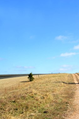 Narrow dirt and gravel lane climbs a hill in North Arkansas and disappears into the blue sky. clipart