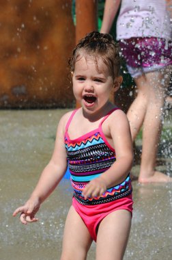 Happiness is written all over this little girl's face as she squeals with delight at a waterpark in Arkansas. clipart