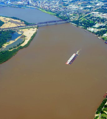 Ariel, Mississippi Nehri 'nin Memphis Nehri Köprüsü ve demiryolu köprüsünün karşısında olduğunu gösteriyor. Römorkör büyük mavnayı itiyor..