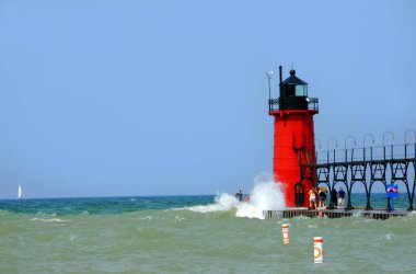 Turistler tehlikeli dalgaları görmezden gelip Michigan Gölü 'ndeki South Haven Deniz Feneri' ni görmek için rıhtımın sonuna gidiyorlar. Yetkililer güvenlik için rıhtımı kapatmaya zorlandılar..