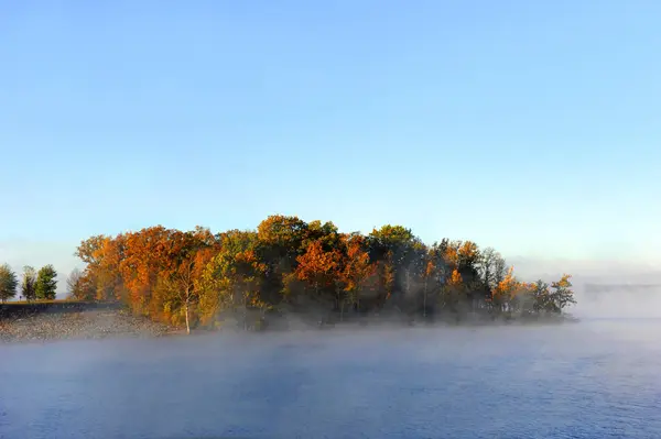 Sabah ışığı Branson, Missouri 'deki Table Rock Gölü kıyılarını aydınlatıyor. Gölden sis yükseliyor..