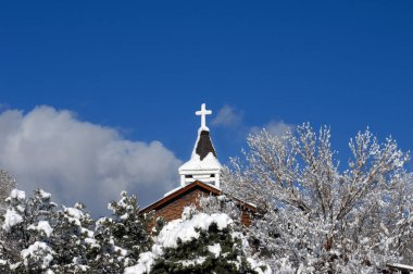 Katolik misyonu yeni bir kar örtüsüyle kaplıdır. Kilise kulesi canlı mavi gökyüzü tarafından çerçevelenmiştir..